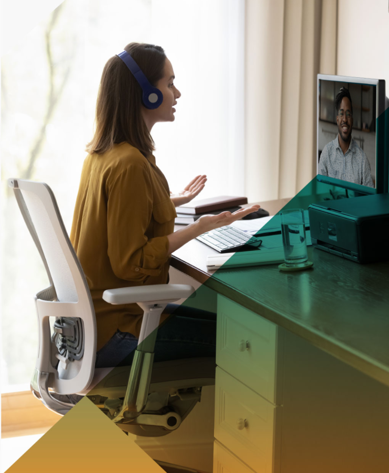 Woman in front of desktop computer with headphones in a video conference meeting